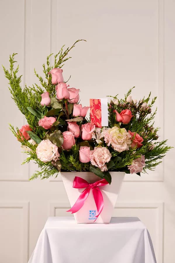 Florero blanco con rosas rosadas
